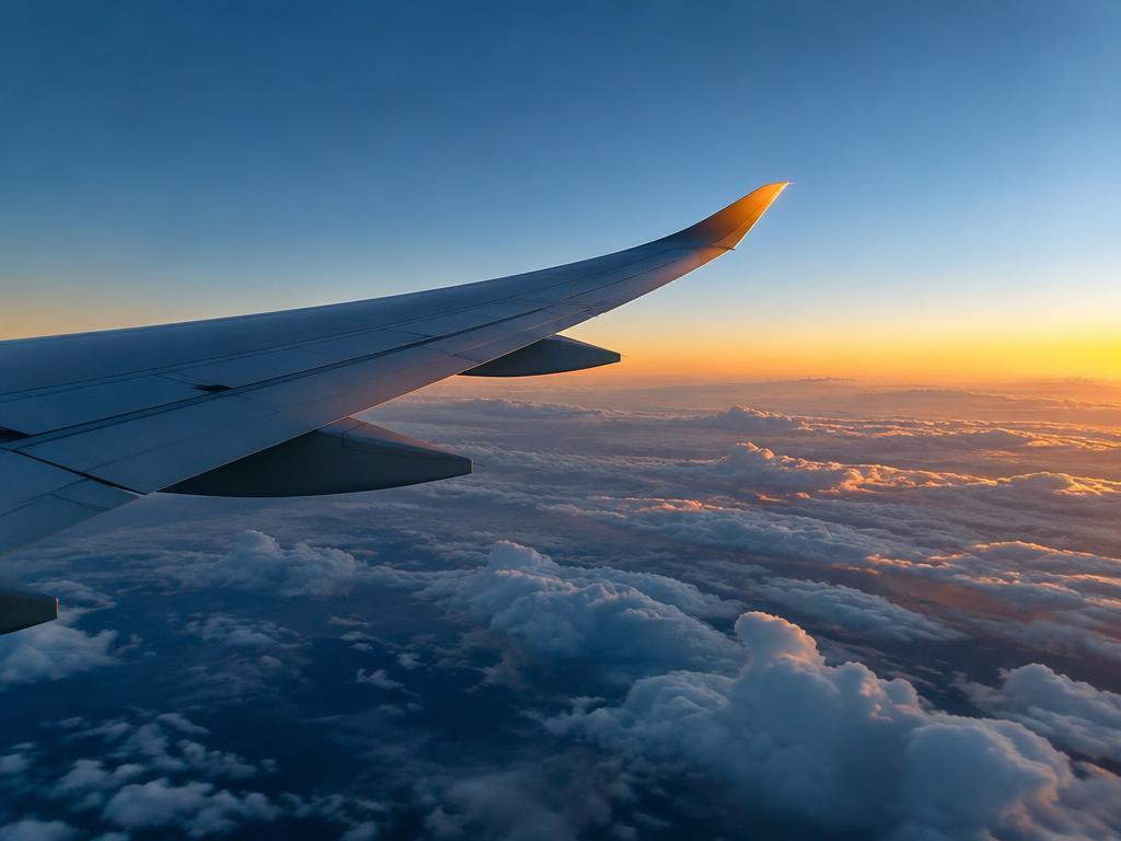 Long-haul flight above the clouds at dawn