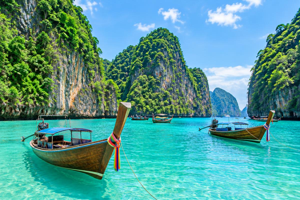 Limestone cliffs and turquoise water in the Phi Phi Islands with longtail boats